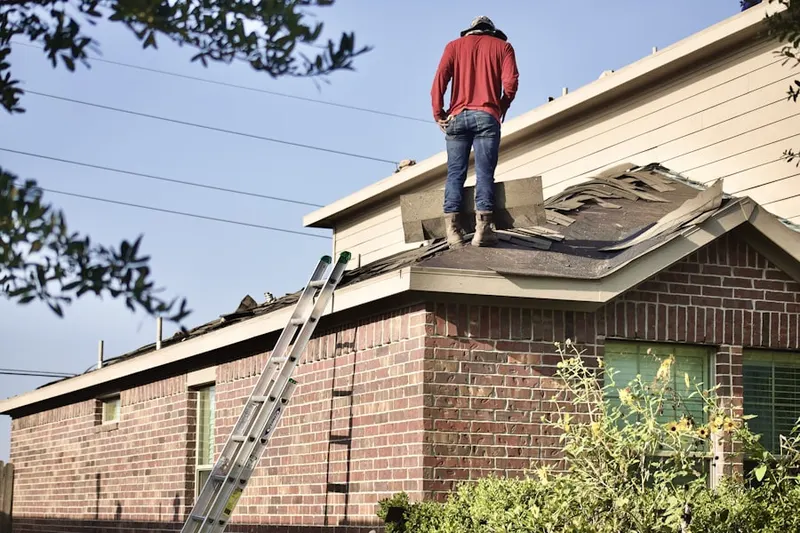 Professional roofer working on a residential roof in Oyster Bay Cove